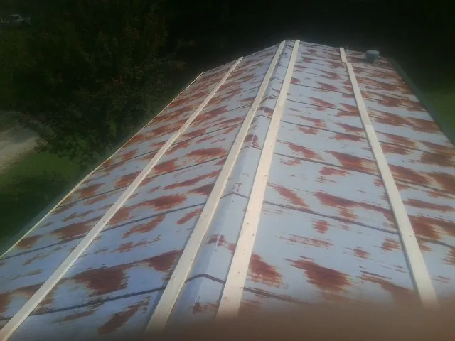 Rusted metal roof panels with new wood purlins before replacement — Storm Damage Roof Repair in North Greece by Roofing Brothers