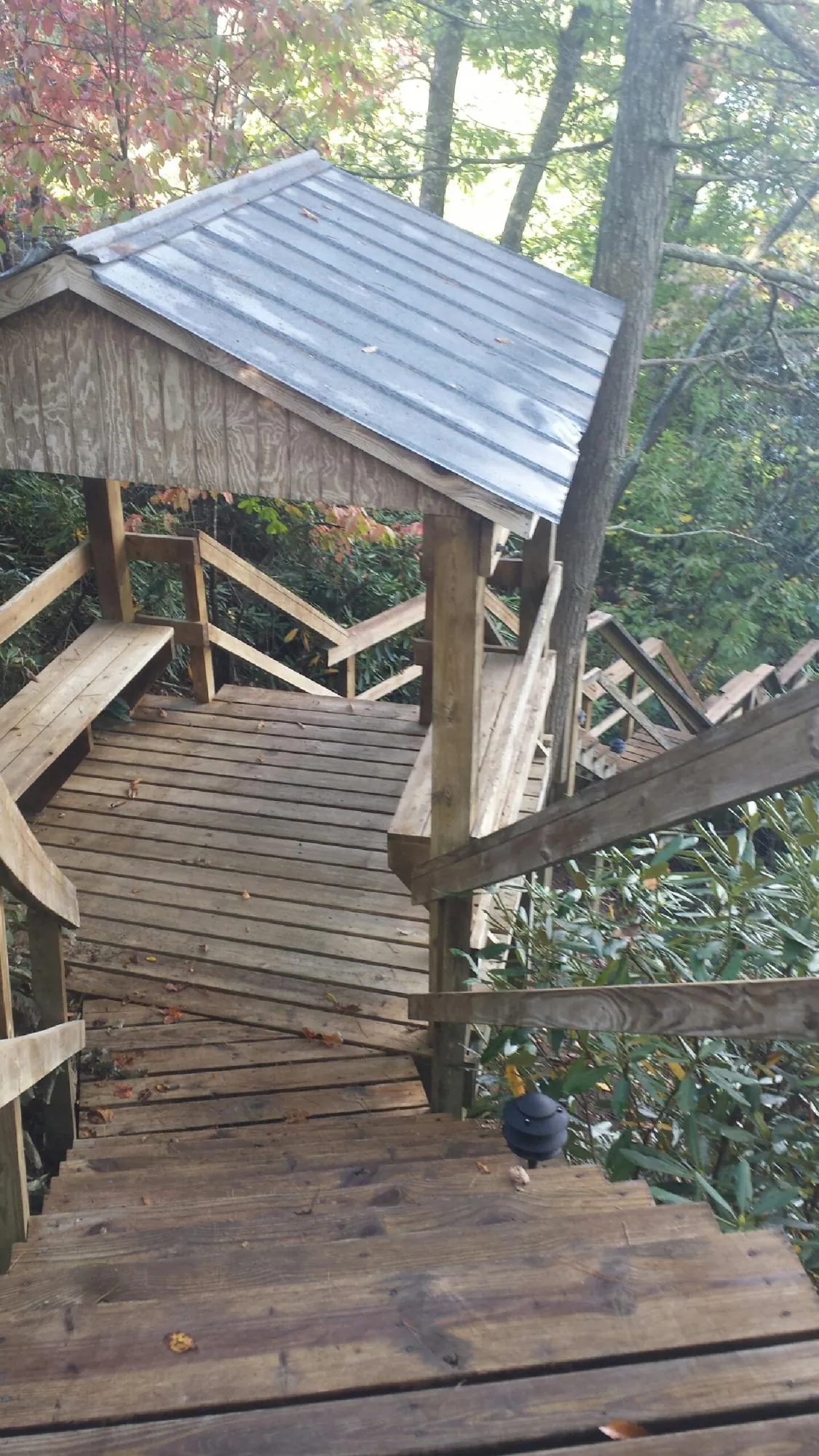 Metal roofed shelter over wooden steps on a wooded walkway — Skylight Repair & Installation work by our crew in North Greece